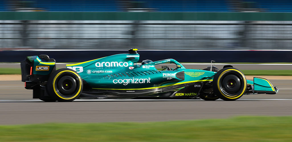 Formula one Aston Martin car at full speed with Cognizant branding on it