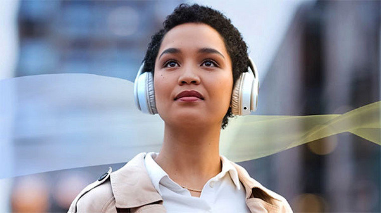 A woman wearing headphones gazes upward