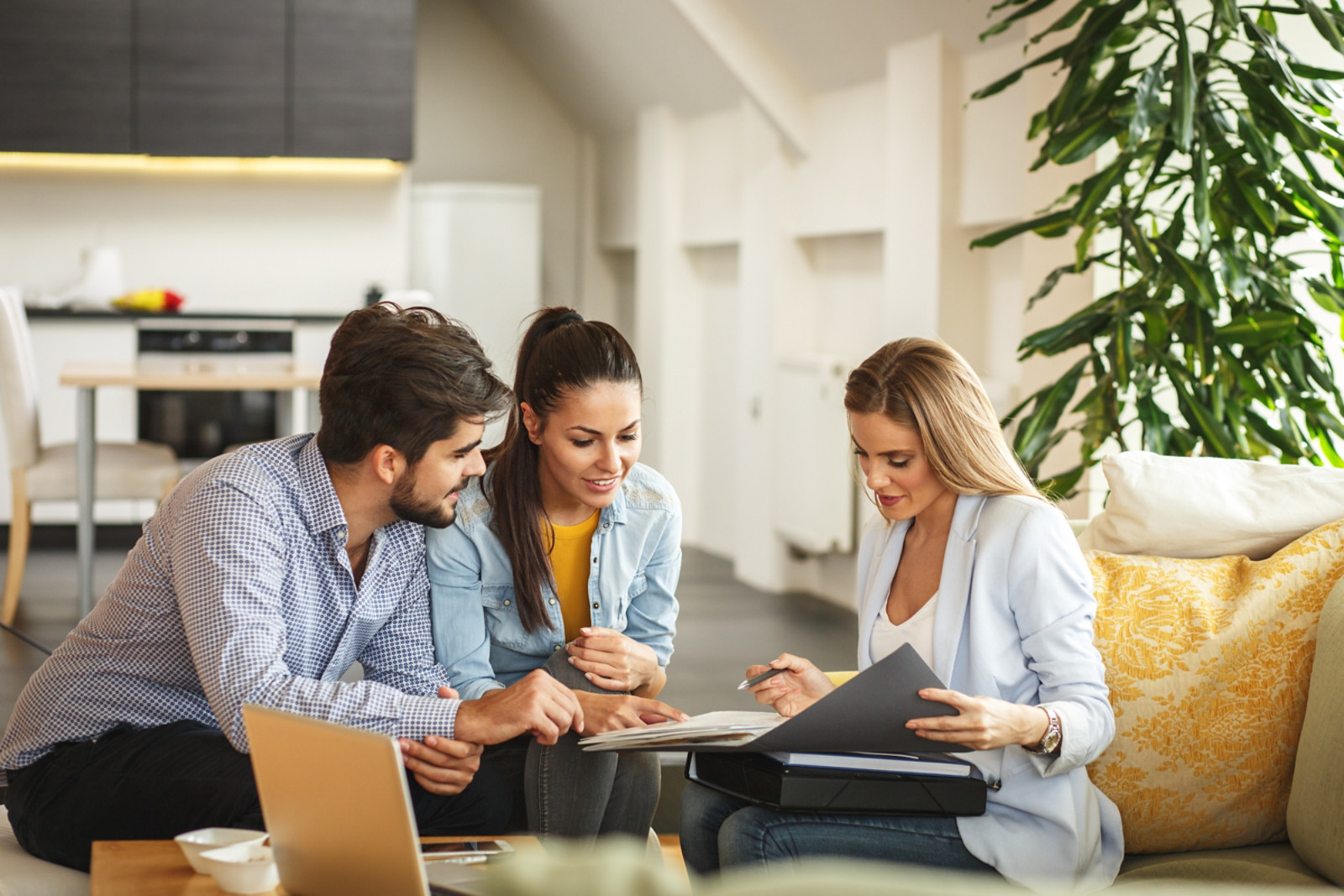 Female Real Estate agent offers home ownership and life insurance to young couple., Female Real Estate agent offers home ownership and life insuranc