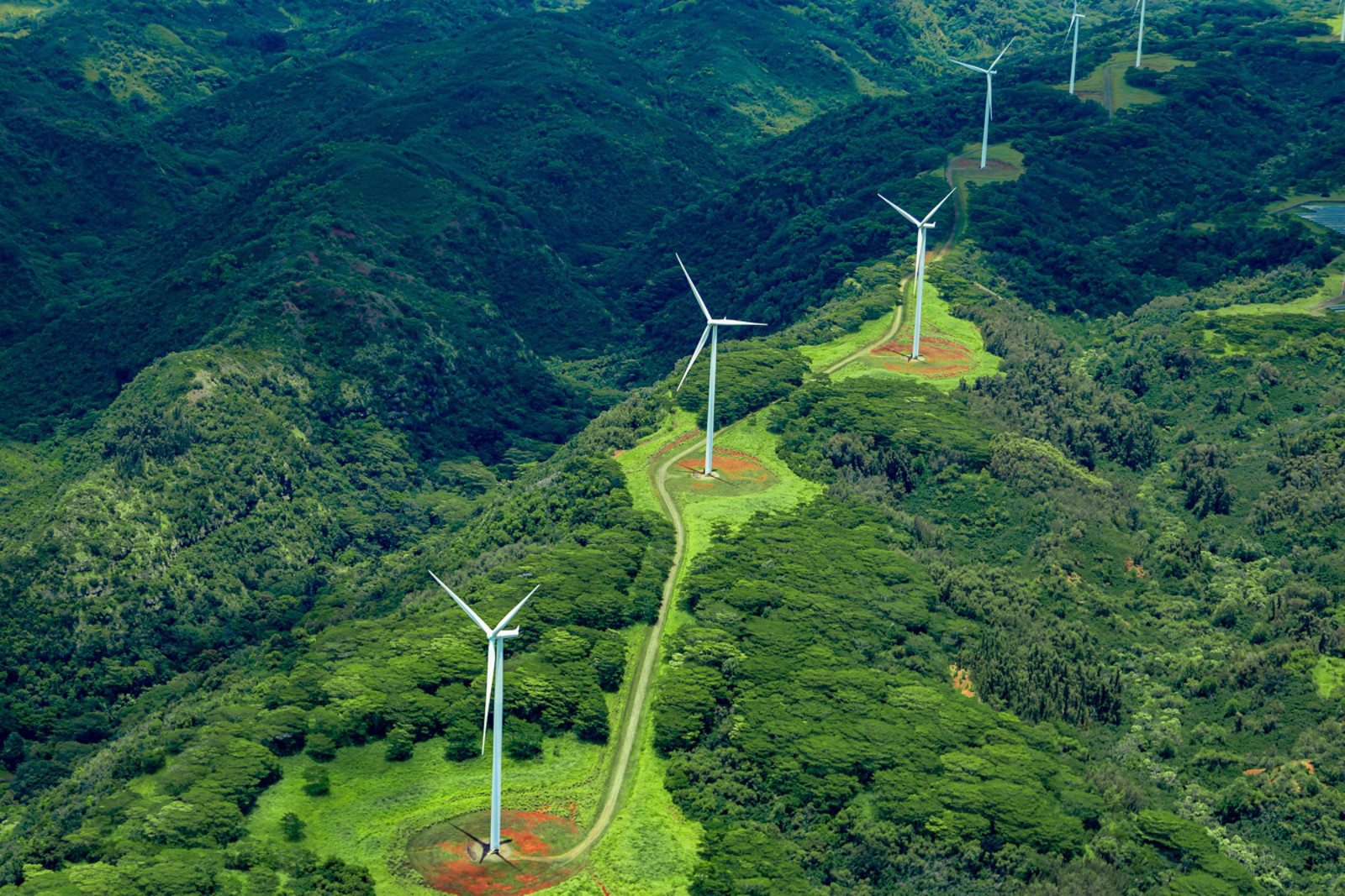 Aerial photo of white windmills in a line on green land leading off into the horizon., Aerial photo of white windmills in a line on green land leading 
