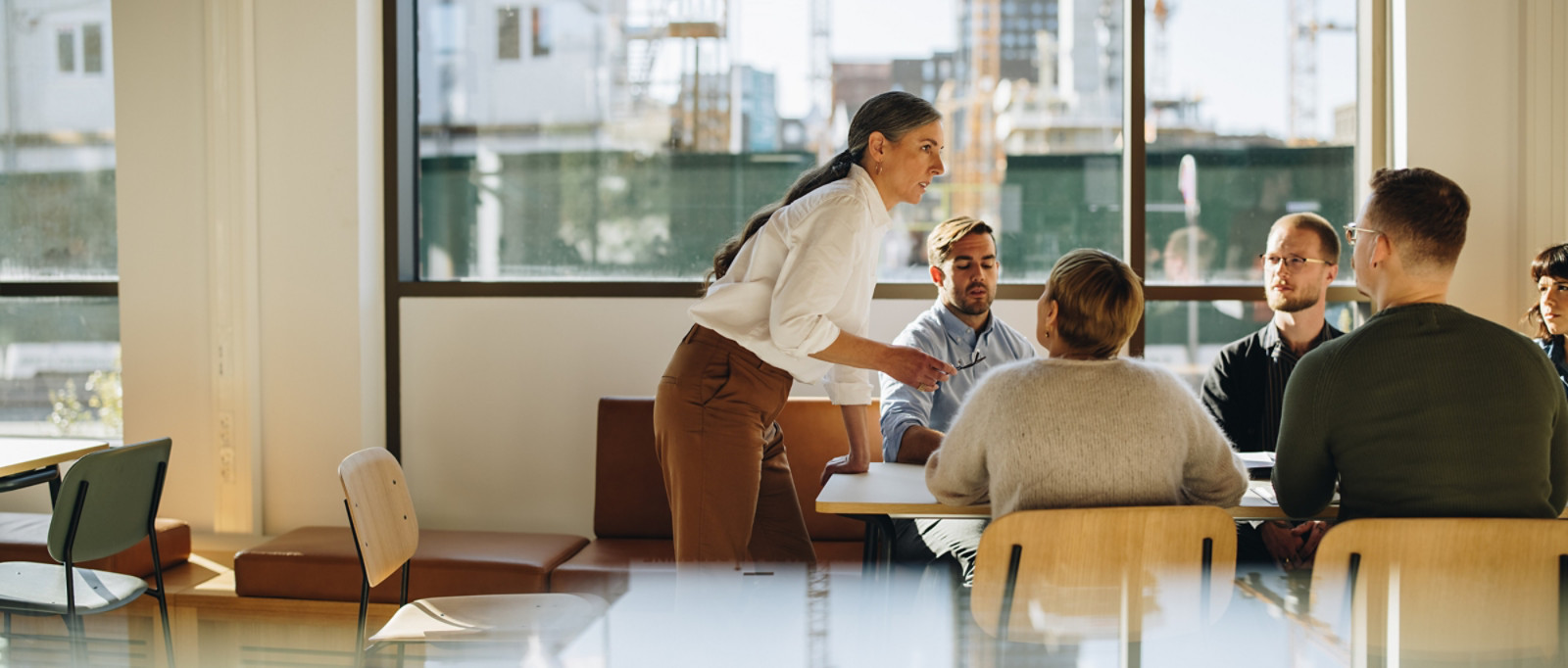 Mature woman leader explaining business strategy. Entrepreneur talking in staff meeting.