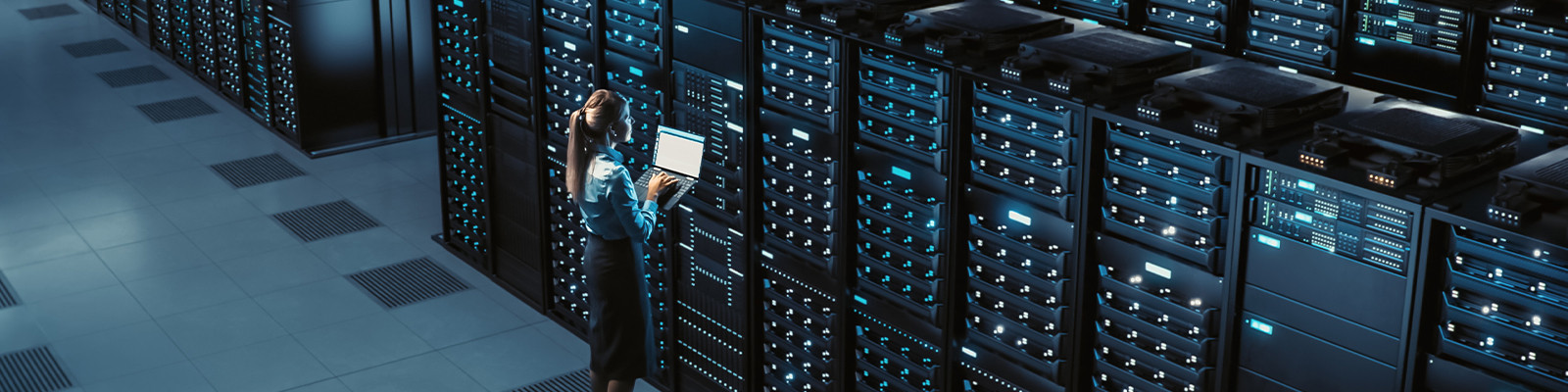 A woman works on a laptop inside the server room