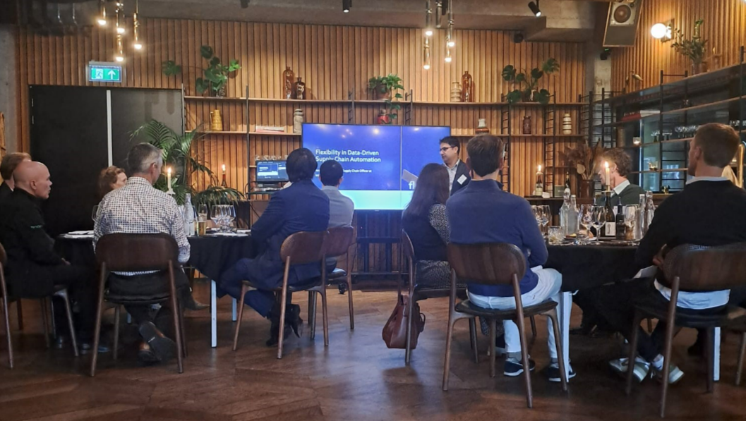 Supply chain roundtable attendees looking at powerpoint intro