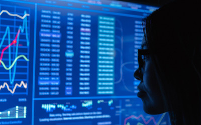 perfil de mujer mirando una pantalla con gráficos