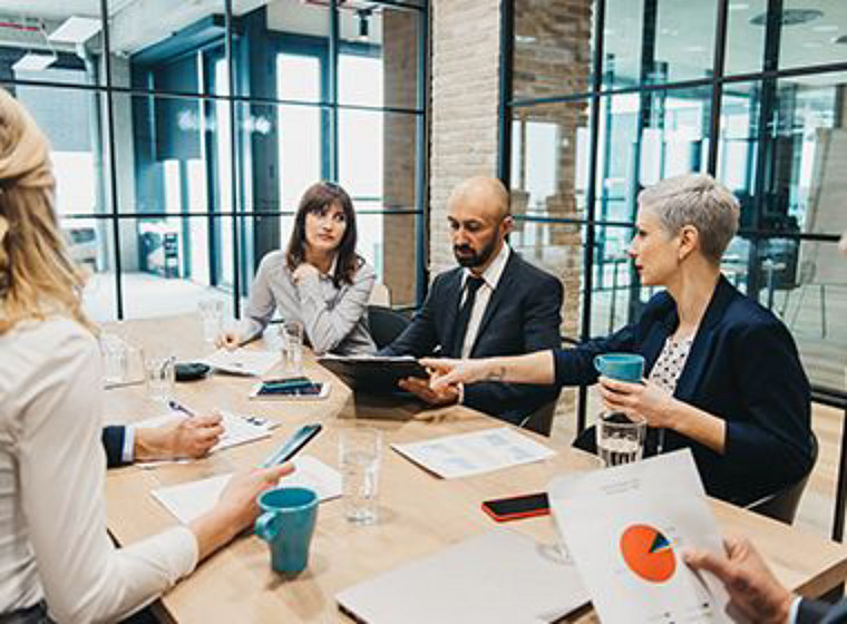 A team of colleagues sitting at a desk disccusing