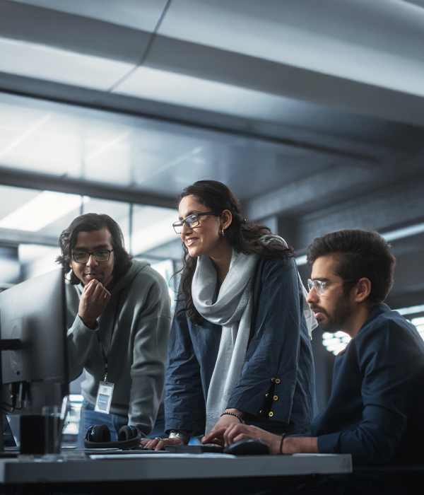 Three individuals focused on their computers
