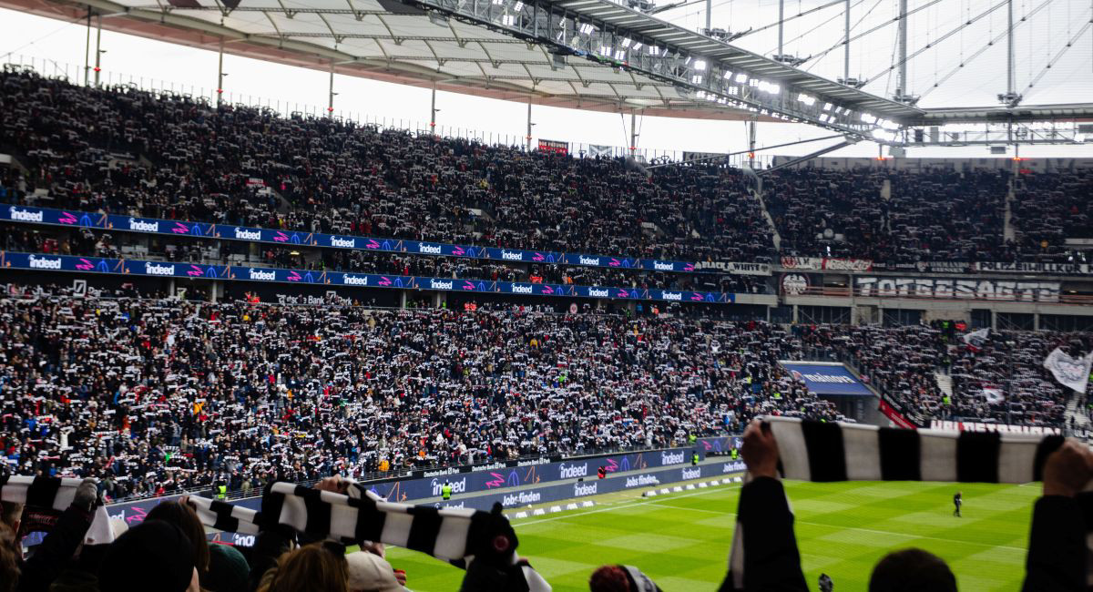 View of a football stadium with people hands