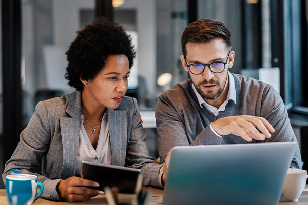 Two people are discussing in front of Laptop