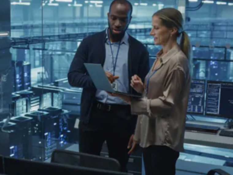 A man showing presenting a laptop screen to a woman at workplace