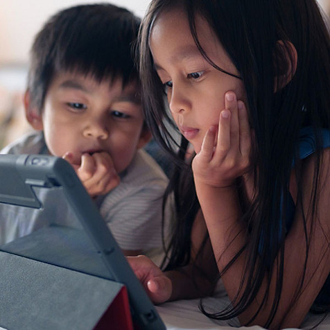 Zwei Kinder schauen auf ein Tablet