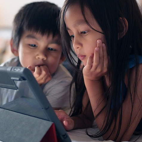 Two kids using an electronic tablet