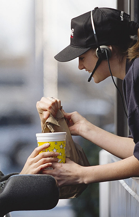 Une femme donne à manger à un voyageur 