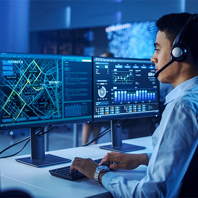 Científico de datos con auriculares trabaja en la computadora en la sala de control.