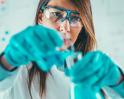 scientist mixing chemicals in flasks