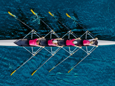 Aerial view of four rowers in perfect synchrony, symbolising unified marketing orchestration.