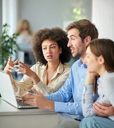 Three people looking at an oipen laptop