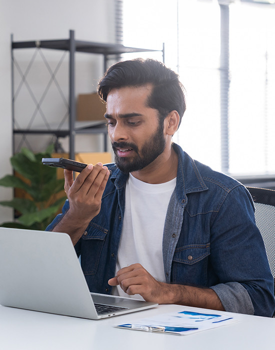 young man seated around a table,  laptops and mobile for work session.