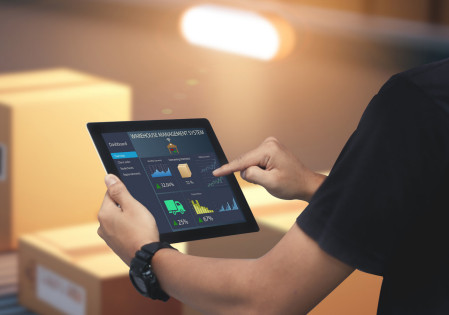 A person working on a tablet, viewed from behind their left shoulder