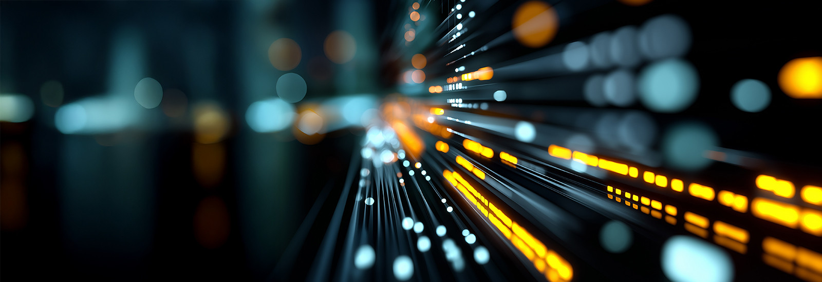 Abstract image depicting a network of glowing orange and white lights on dark background, resembling fiber-optic cables, conveying a sense of speed and technology.
