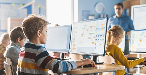 Students in a classroom looking at monitors