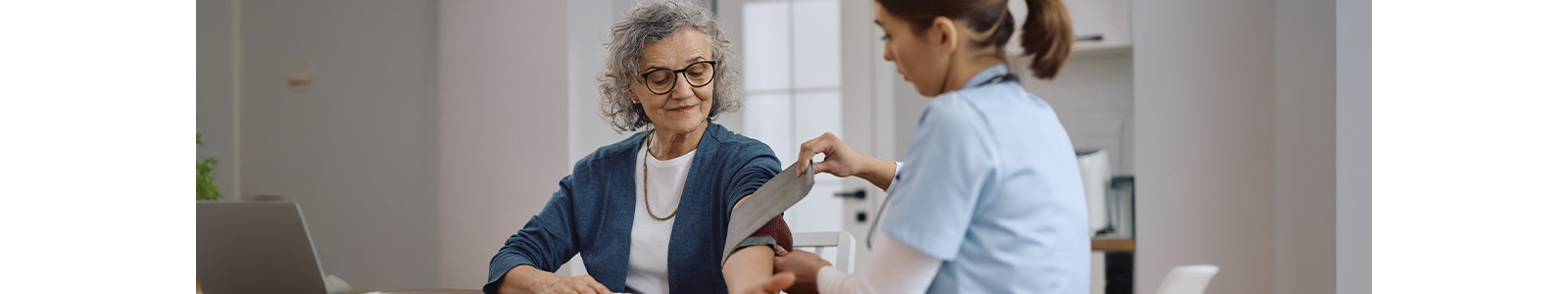 A Doctor checking with BP machine to a old lady