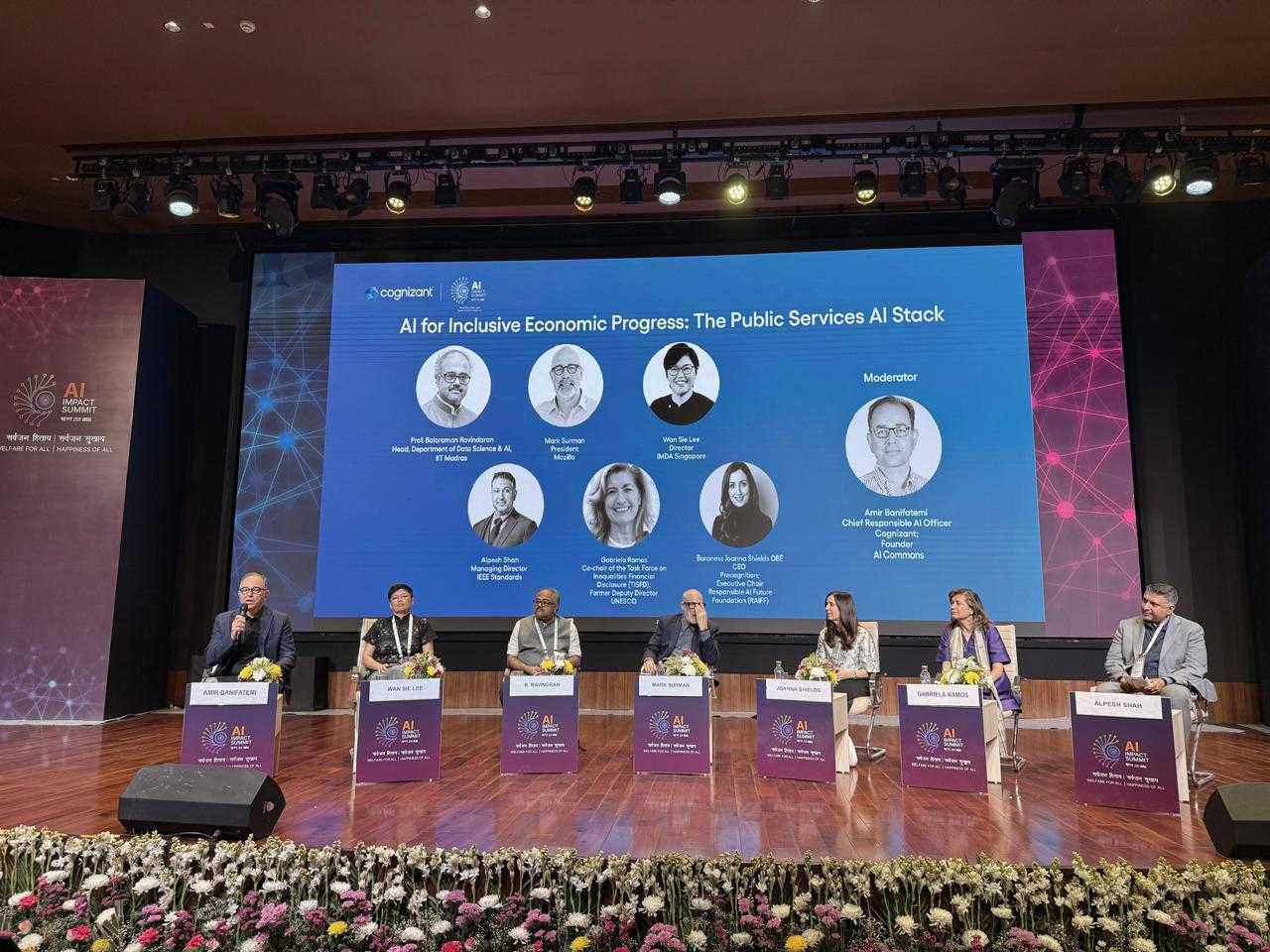 Panelists on a large stage at a conference
