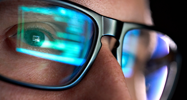 Man wearing spectacles staring at a computer screen