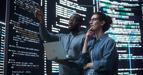 man and woman looking at digital screens