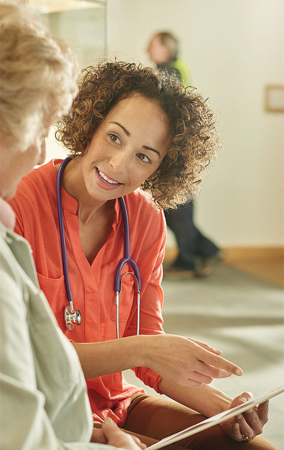 Doctor leans over slightly while talking to patient