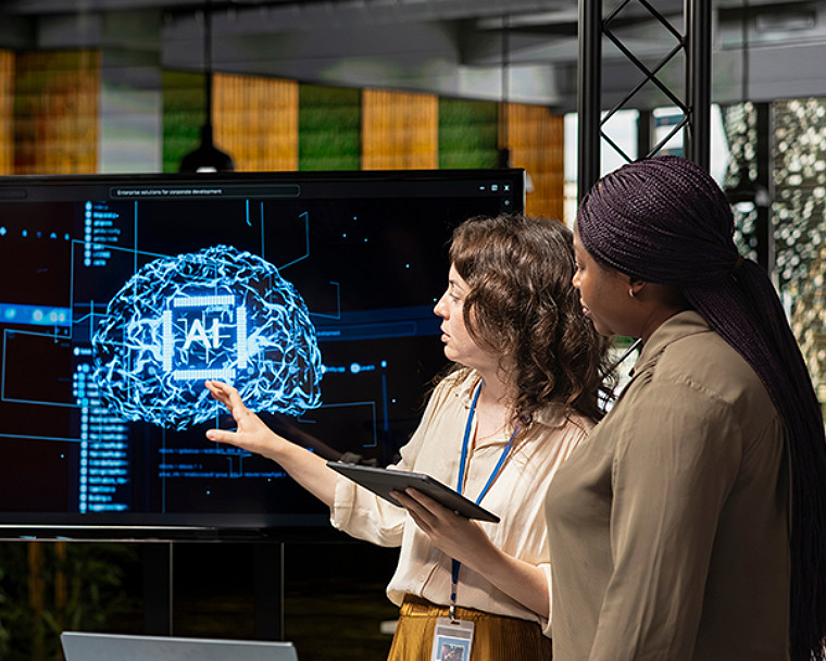 Two people reviewing an AI brain visualization on screen.