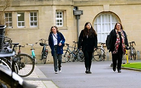 Three students walking through the campus