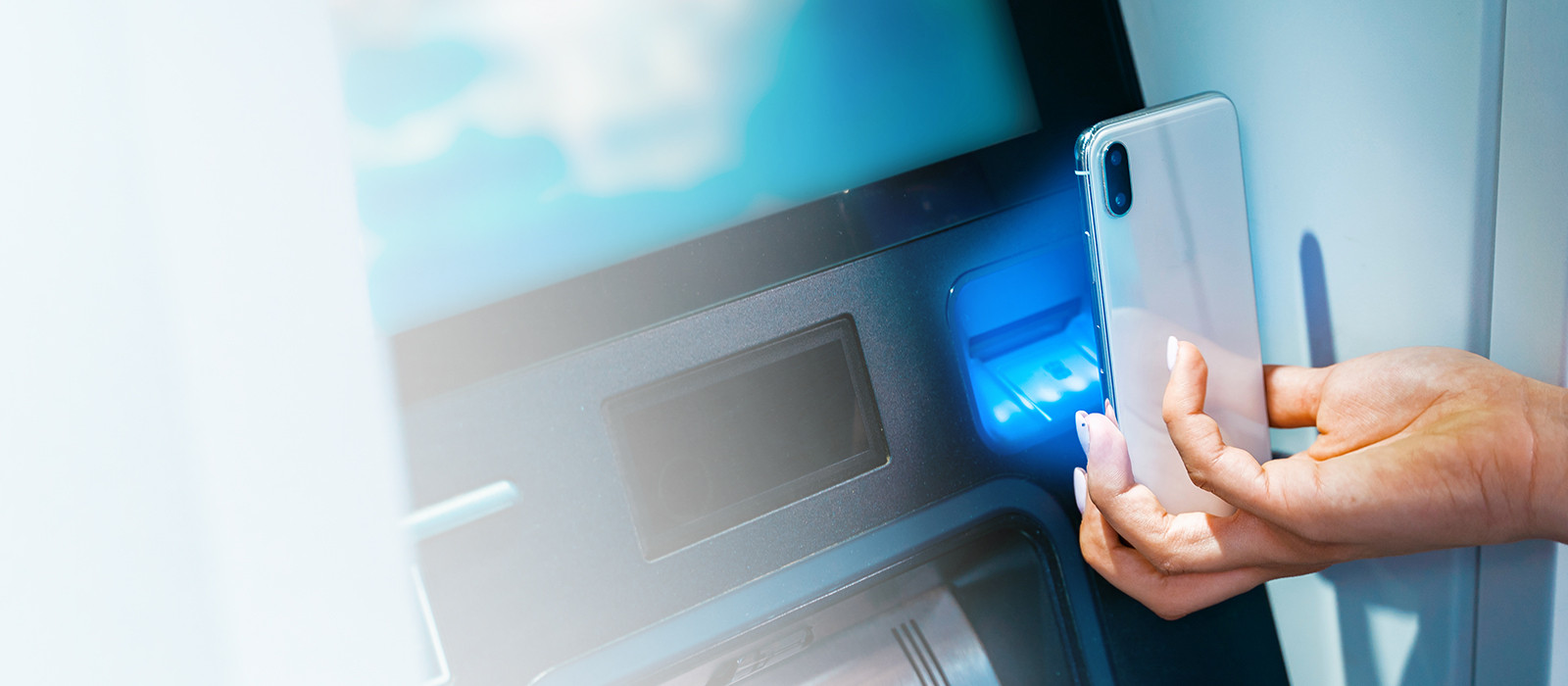 Mobile phone being held in front of  an ATM machine to be scanned