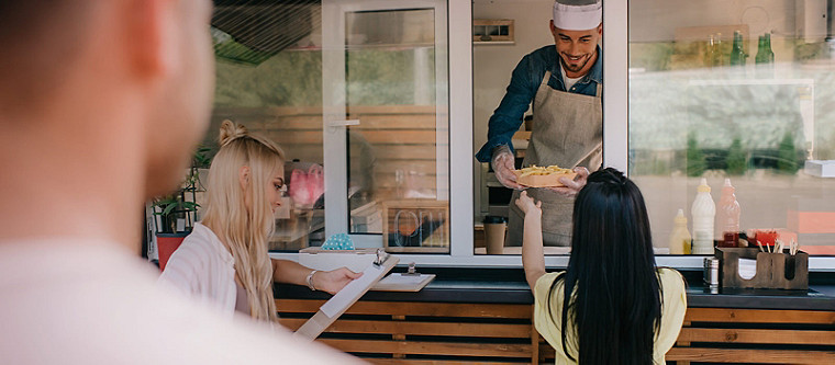 chef handing out plate of food to woman