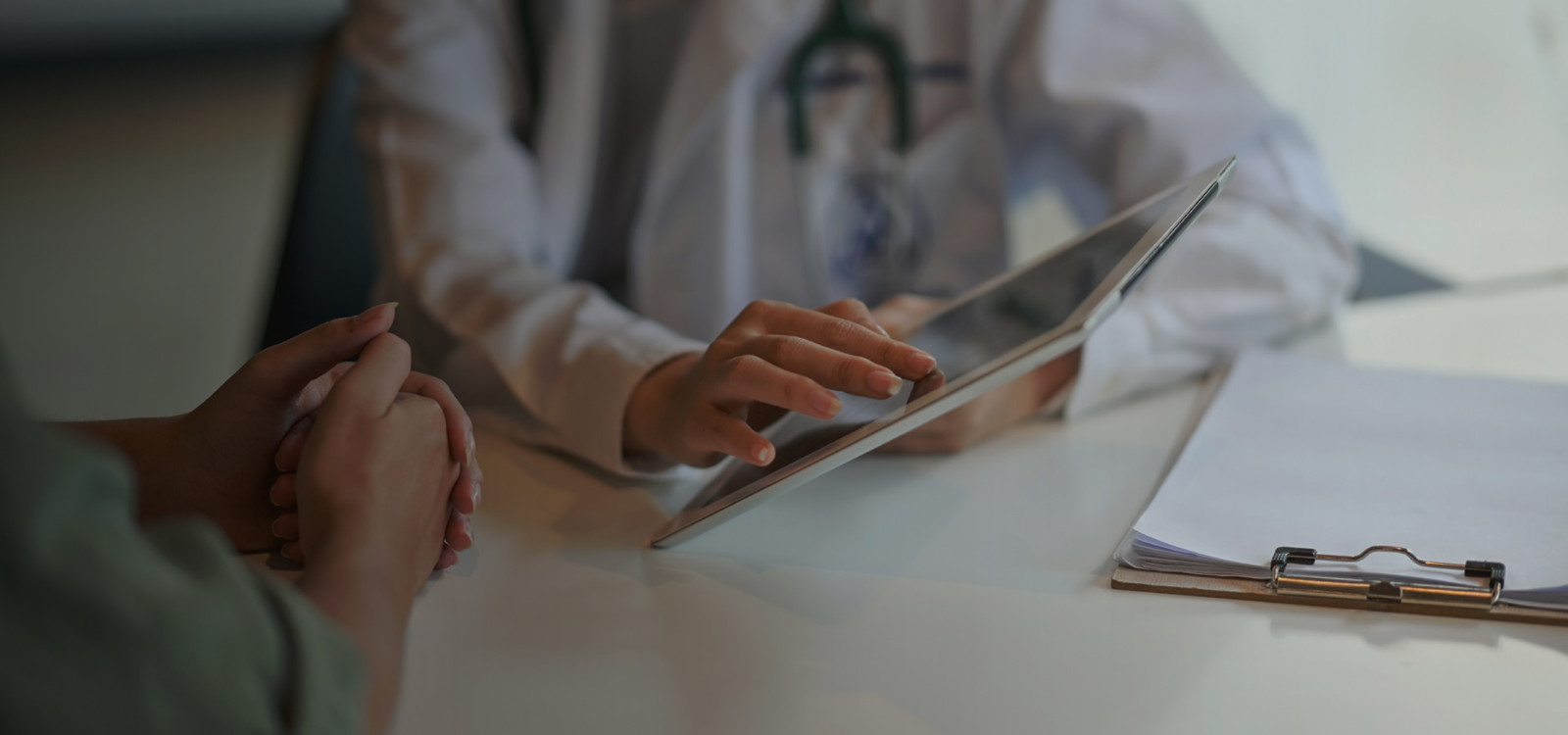 doctor showing something on tablet to other person