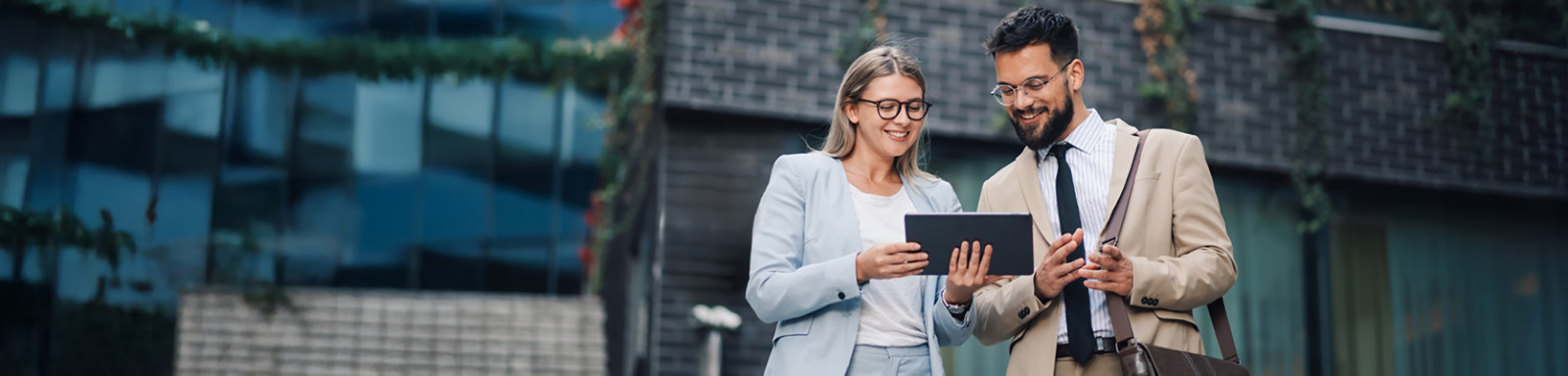 Un hombre y una mujer sostienen juntos una tablet, probablemente compartiendo ideas