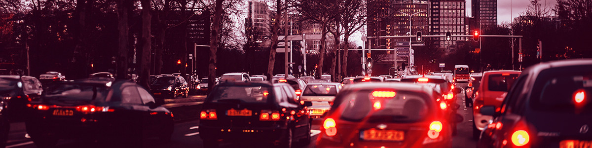 A bustling city filled with cars and illuminated traffic lights guiding the flow of traffic