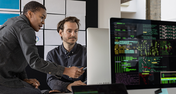 dos personas mirando una pantalla de ordenador