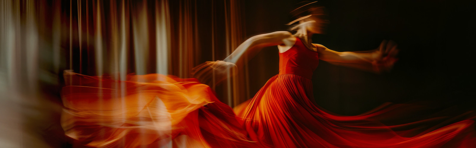 Dancer in red dress spinning with motion blur