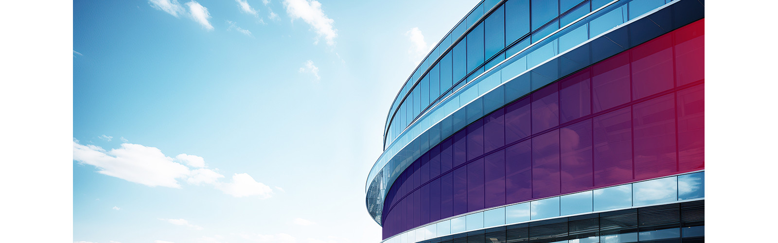 Top portion of a building with glass panes an a circular frontage