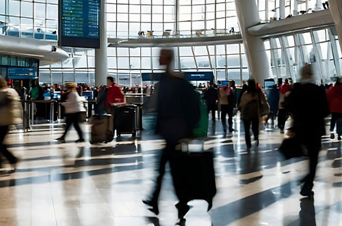 A busy airport terminal with people walking around motion blurred