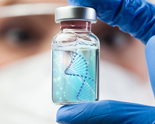 Eine Nahauf­nahme eines Wissenschaftlers, der eine DNA-Probenflasche in der Hand hält.