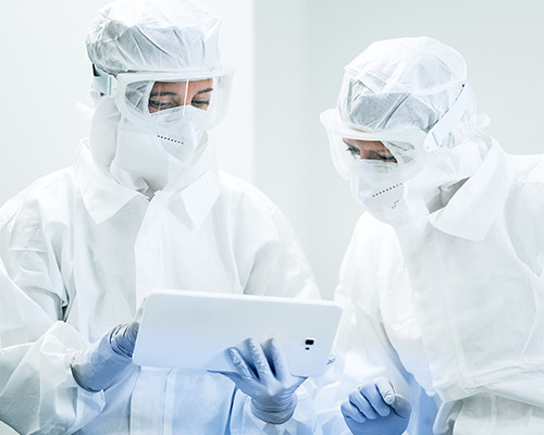Two scientists looking at a tablet, held by one of them.