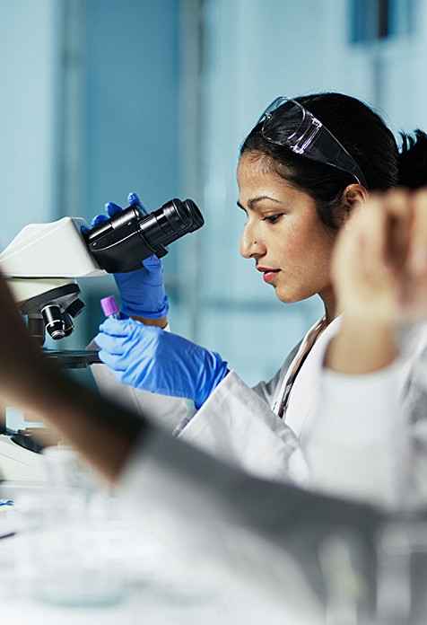 Female scientist using a microscope