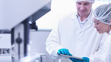 Zwei Wissenschaftler, die mit einem Tablet in der Hand im Labor arbeiten