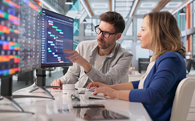 Two colleagues reviewing workflow automation and business process management dashboard.