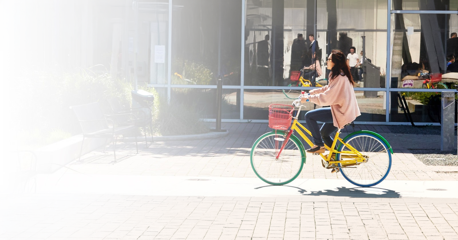 A girl riding a bycycle outside google office