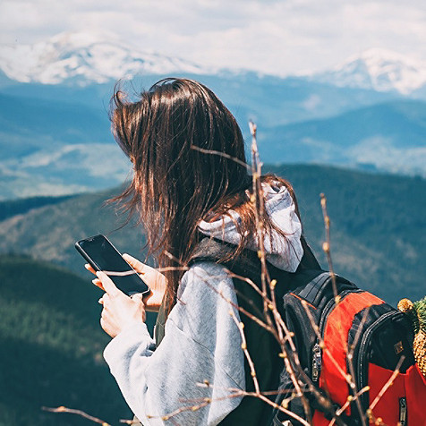 woman on mountain using smartphone