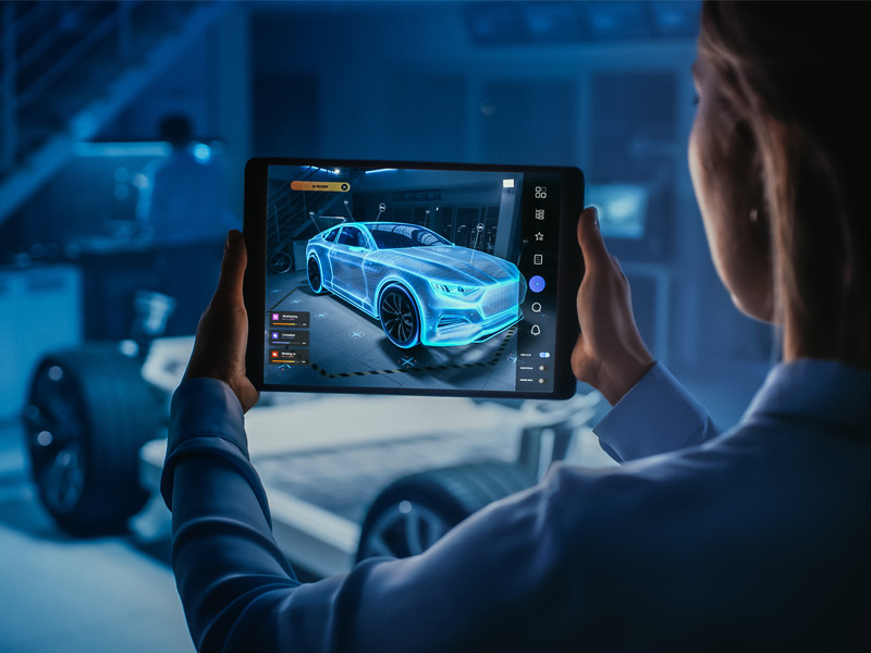 A person viewing a futuristic car on tablet.
