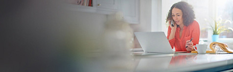 Woman talking on the phone in front of her laptop