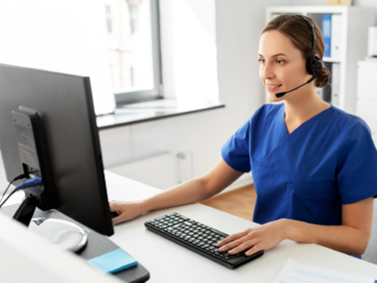 A woman wearing headphones working on a desktop